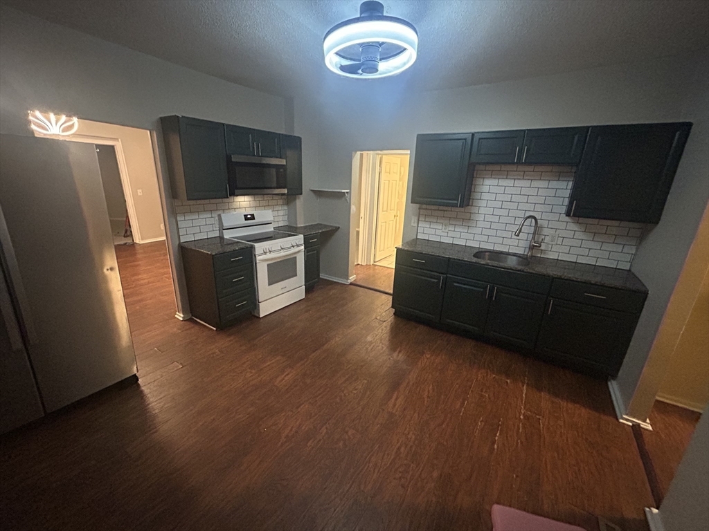 62 Washburn Street Springfield, MA 01107 - Photo 2 of 16 a kitchen with stainless steel appliances granite countertop a stove a sink and a refrigerator