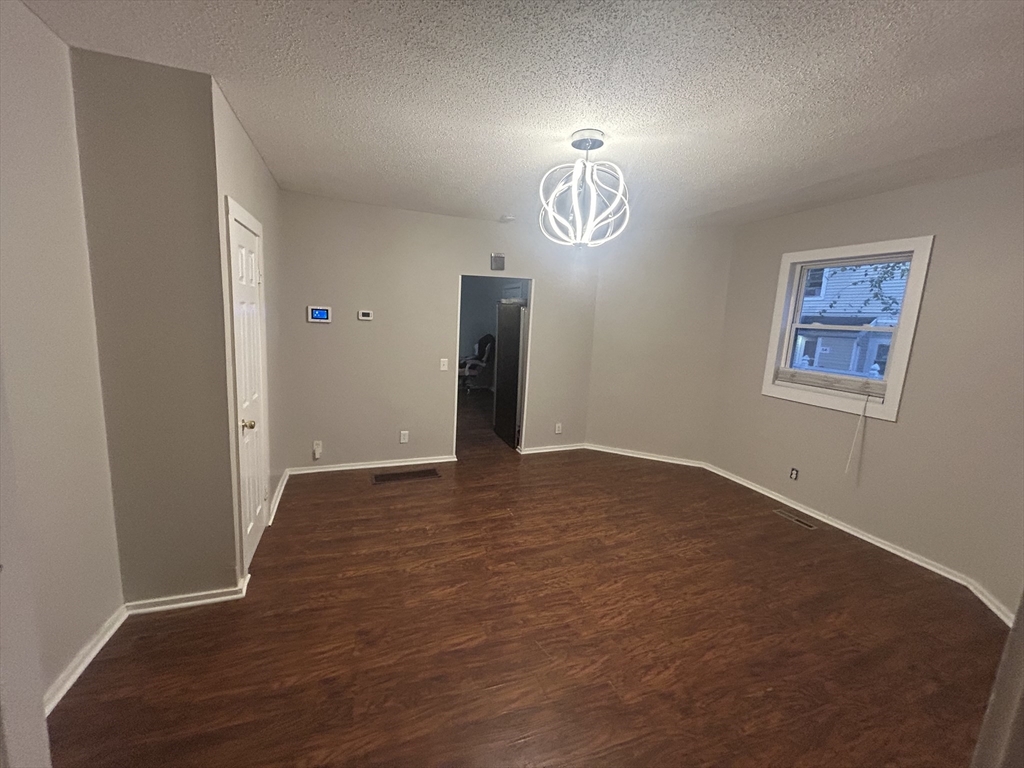 62 Washburn Street Springfield, MA 01107 - Photo 5 of 16 an empty room with a wooden floor and window