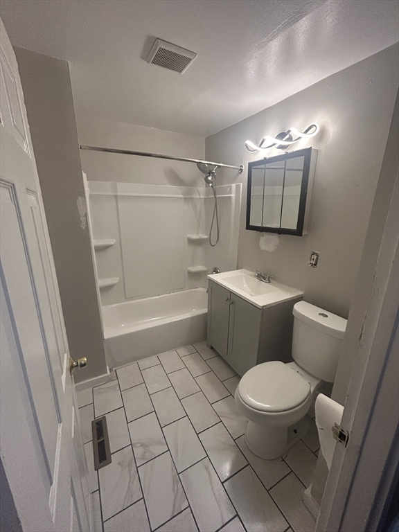 62 Washburn Street Springfield, MA 01107 - Photo 6 of 16 a bathroom with a toilet a sink a mirror and shower