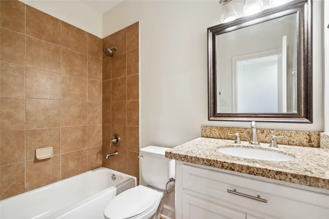 a bathroom with a granite countertop sink a mirror and a bathtub