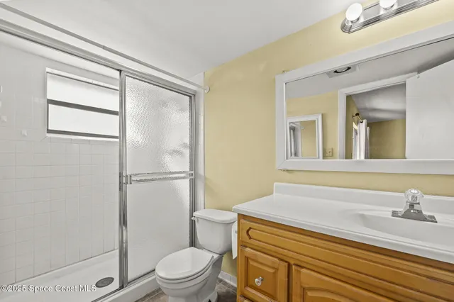 a bathroom with a sink a toilet a mirror and shower