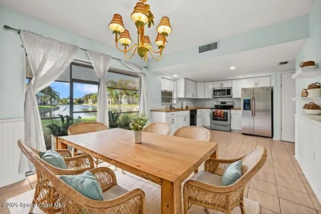 a view of a dining room with furniture a chandelier and wooden floor