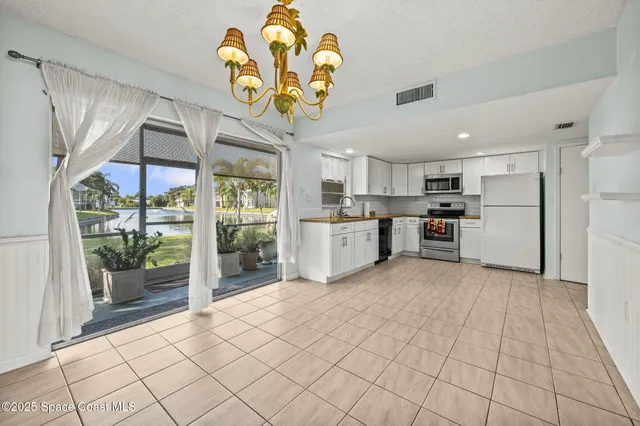 a kitchen with stainless steel appliances granite countertop a stove a refrigerator a sink a microwave oven with cabinets and refrigerator