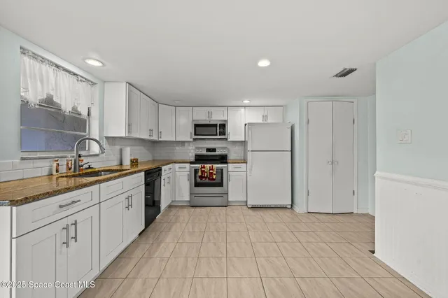 a kitchen with stainless steel appliances granite countertop a refrigerator and a sink