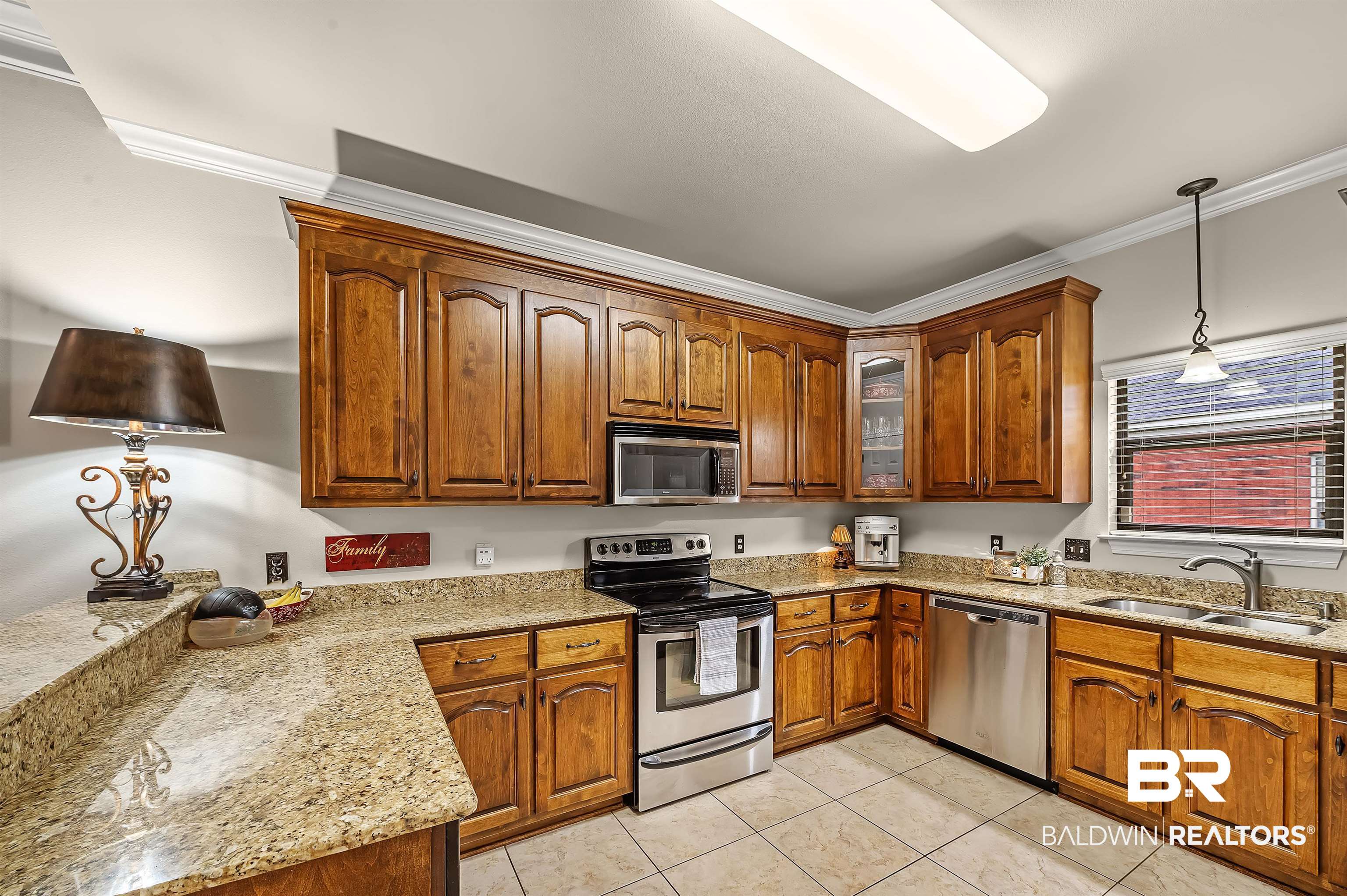9376 Sable Court Daphne, AL 36526 - Photo 20 of 46 Kitchen featuring light stone countertops, crown molding, stainless steel appliances, sink, and hanging light fixtures
