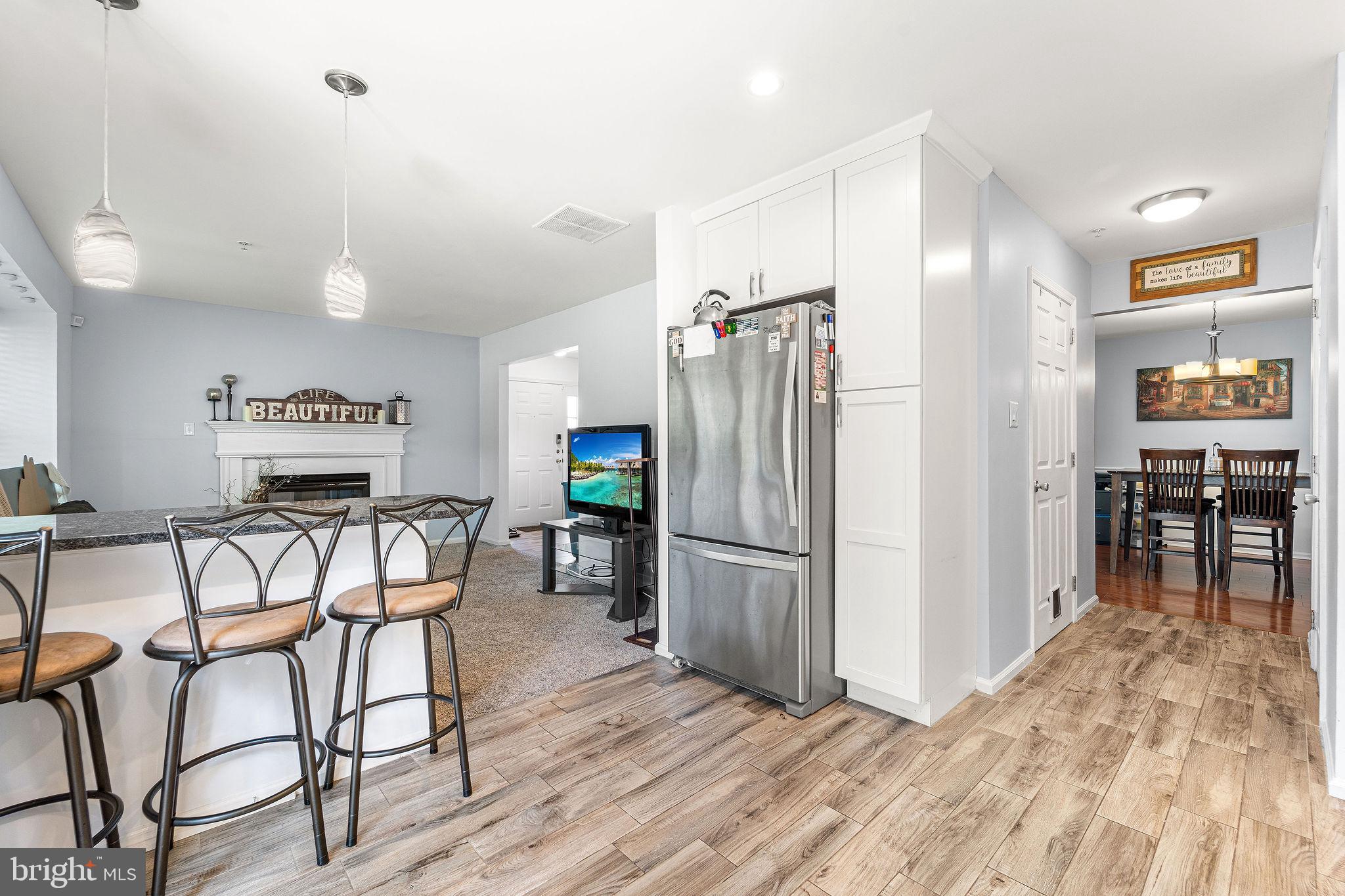 803 Tanglewood Drive Sicklerville, NJ 08081 - Photo 11 of 26 a kitchen with stainless steel appliances refrigerator dining table and chairs