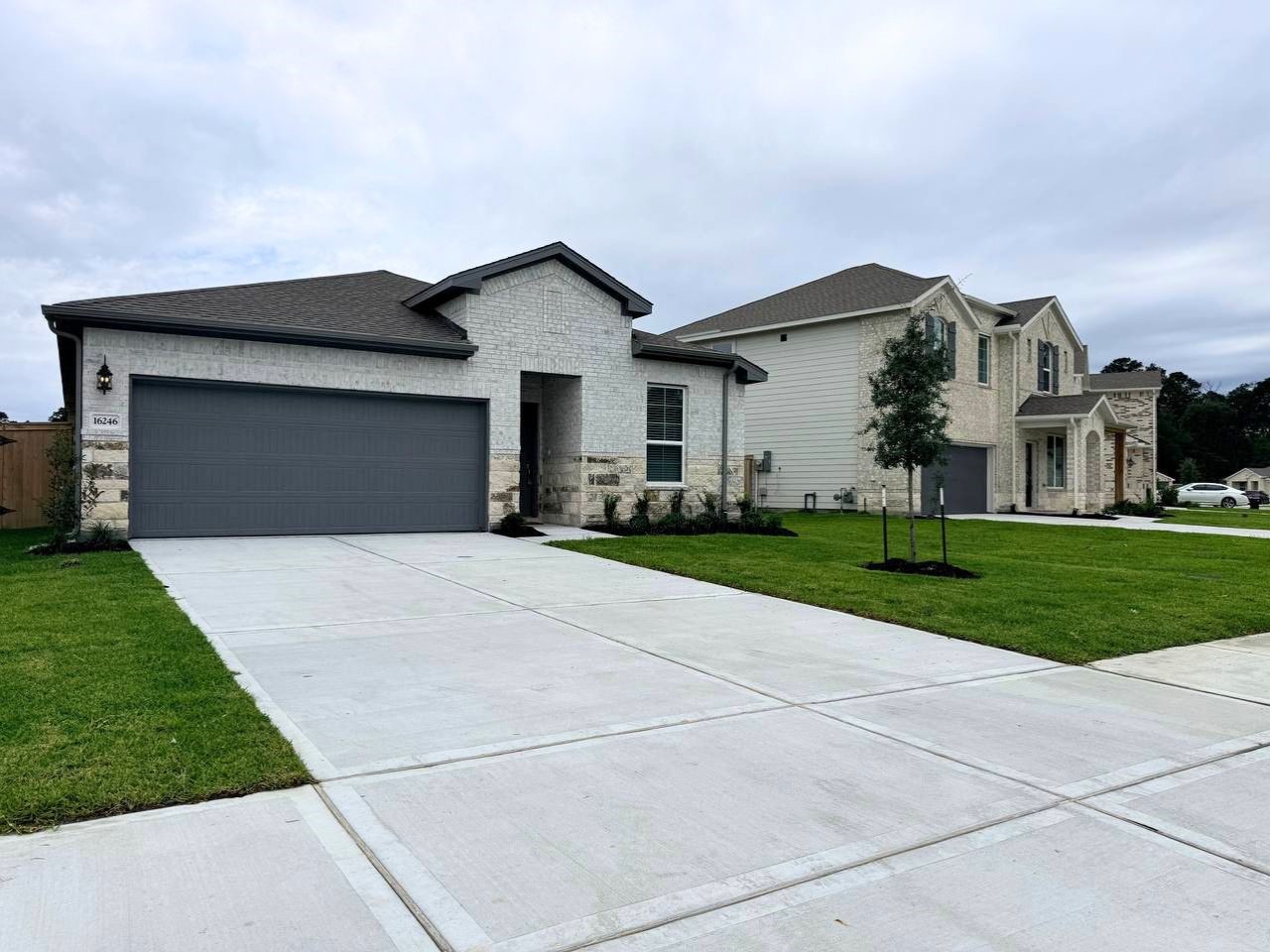 16246 Parish Pointe Court Conroe, TX 77302 - Photo 2 of 32 a front view of a house with a yard and garage