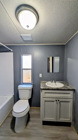 a bathroom with a granite countertop toilet sink and mirror