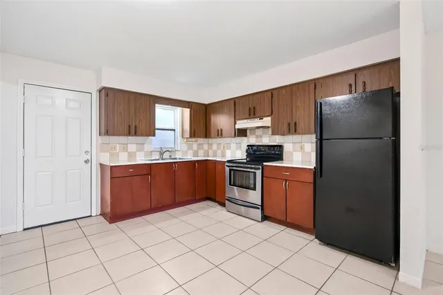 a kitchen with granite countertop a refrigerator and a sink