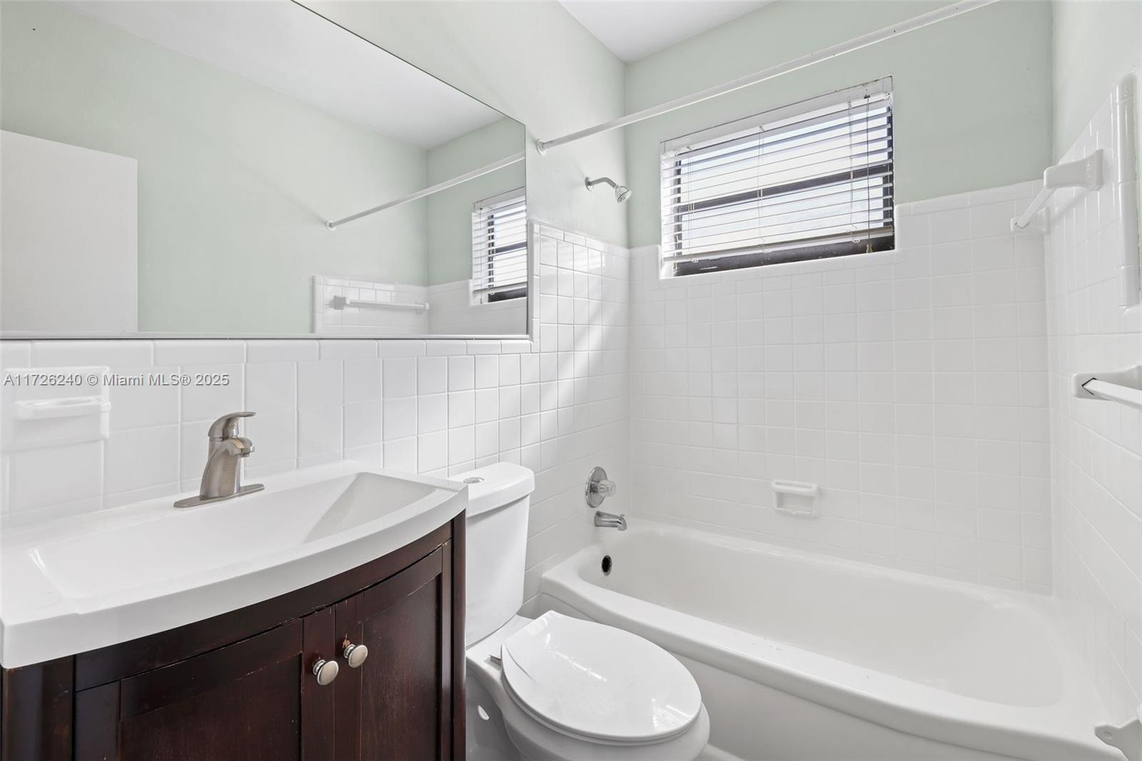 7745 Harding Avenue, Unit 22 Miami Beach, FL 33141 - Photo 4 of 9 a bathroom with a sink a toilet and bathtub