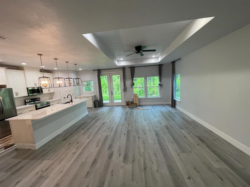 4102 Northwest 26th Drive Gainesville, FL 32605 - Photo 2 of 11 a view of a kitchen with a sink wooden floor and a large window