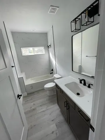 a bathroom with a double vanity sink mirror and toilet