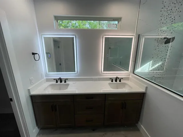 a bathroom with a double vanity sink and a mirror