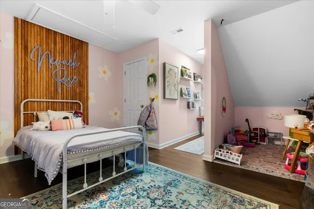 a bedroom with a bed and a flat tv screen on the dresser