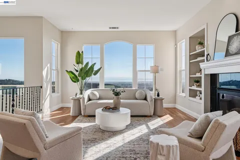 a living room with furniture floor to ceiling window and wooden floor