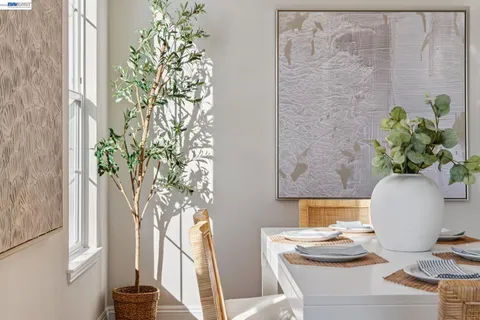 a dining room with furniture potted plants and wooden floor