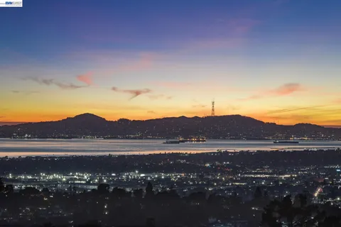 a view of mountain with sunset in background