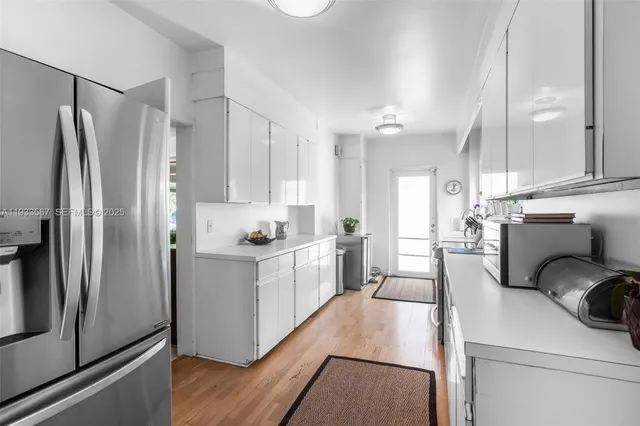 a kitchen with white cabinets and stainless steel appliances