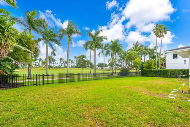 a view of a fountain in a yard with palm trees