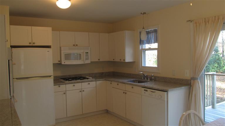 482 Lincoln Extension Road Hyannis, MA 02601 - Photo 3 of 16 a kitchen with white cabinets sink and refrigerator