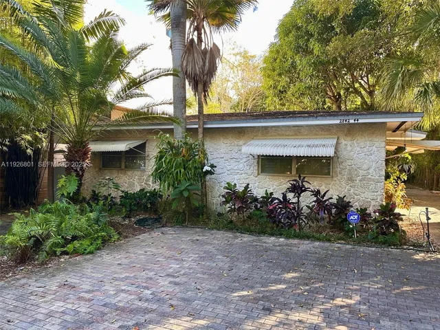 a front view of a house with a garden
