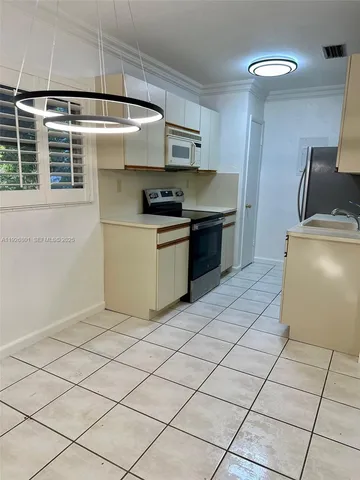 a kitchen with stainless steel appliances a sink a stove a refrigerator and cabinets