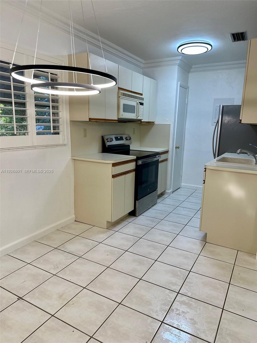 2842 Coconut Avenue, Unit B Miami, FL 33133 - Photo 16 of 23 a kitchen with stainless steel appliances a stove a sink and a refrigerator