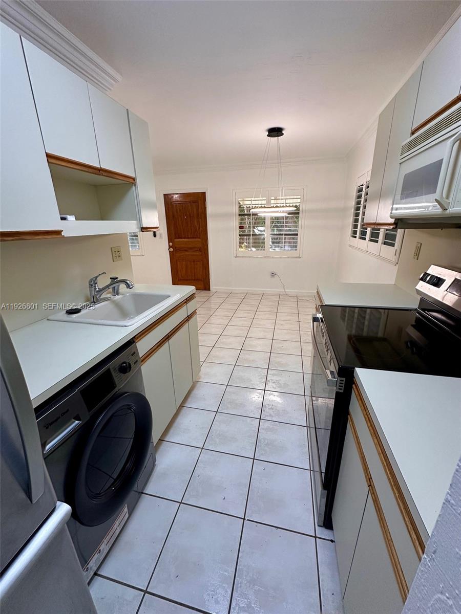 2842 Coconut Avenue, Unit B Miami, FL 33133 - Photo 20 of 23 a kitchen with a sink a stove and a microwave