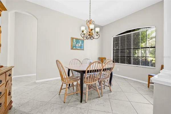 a dining room with furniture a chandelier and window