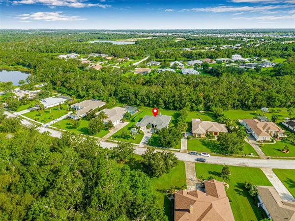 an aerial view of residential houses with outdoor space and trees