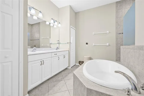 a spacious bathroom with a bathtub sink and mirror