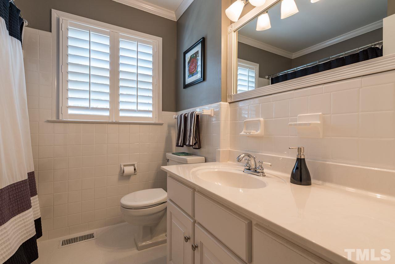 2320 Ridge Road Raleigh, NC 27612 - Photo 14 of 25 a bathroom with a sink a toilet and a window