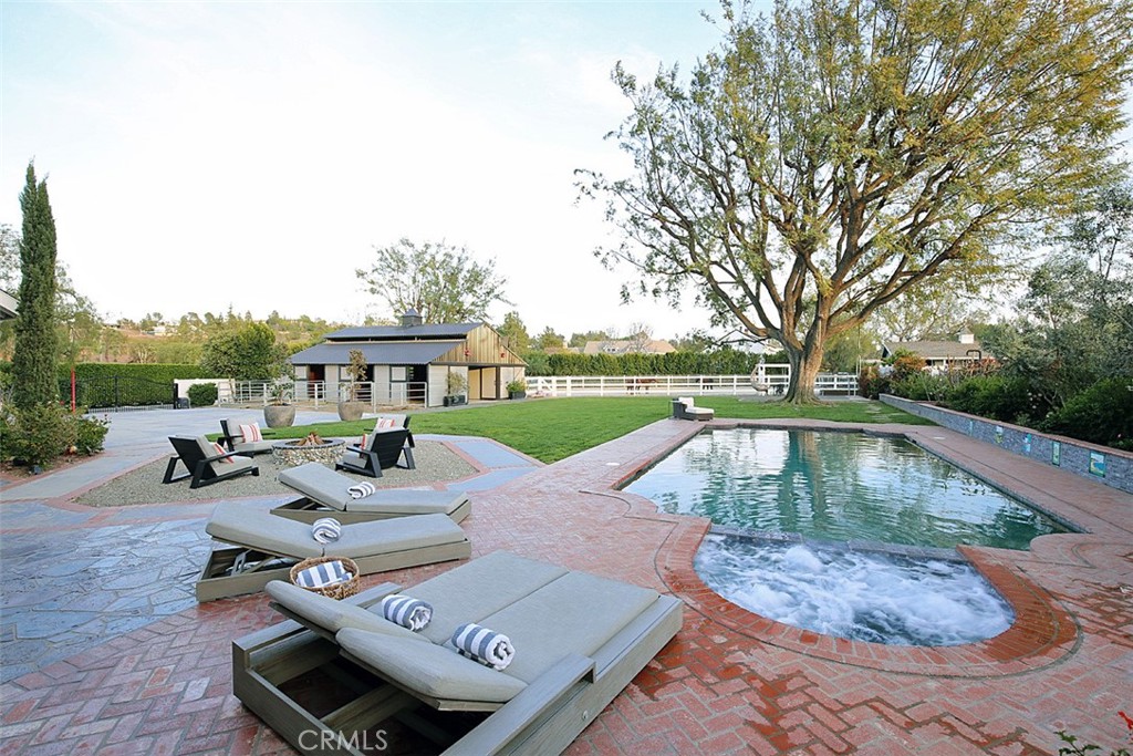 a view of backyard with swimming pool and outdoor seating