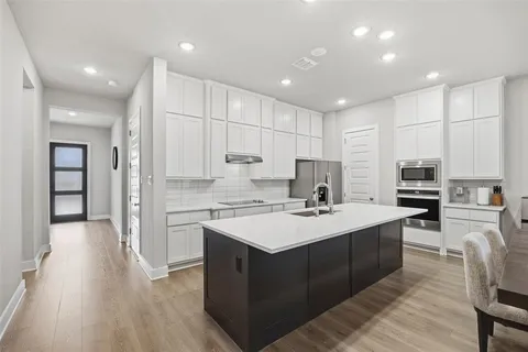 a kitchen with a sink stove cabinets and refrigerator