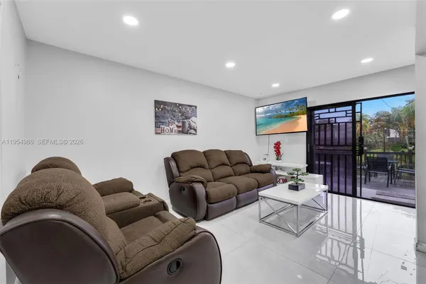 a living room with furniture potted plant and a large window