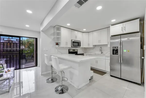 a kitchen with a refrigerator a sink and cabinets