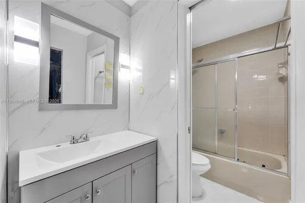 a bathroom with a shower sink vanity and mirror