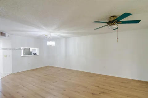 a view of a room with wooden floor and fan