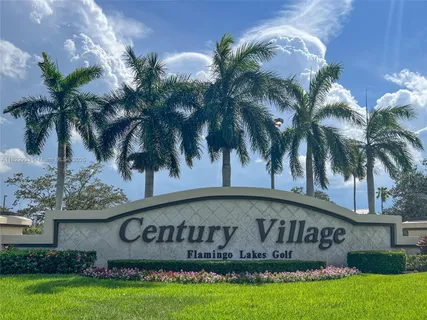 a front view of multi story residential apartment building with yard and sign board