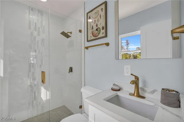 a bathroom with a sink and mirror with toilet