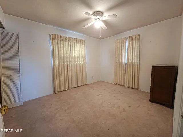 a view of a livingroom with a ceiling fan and window