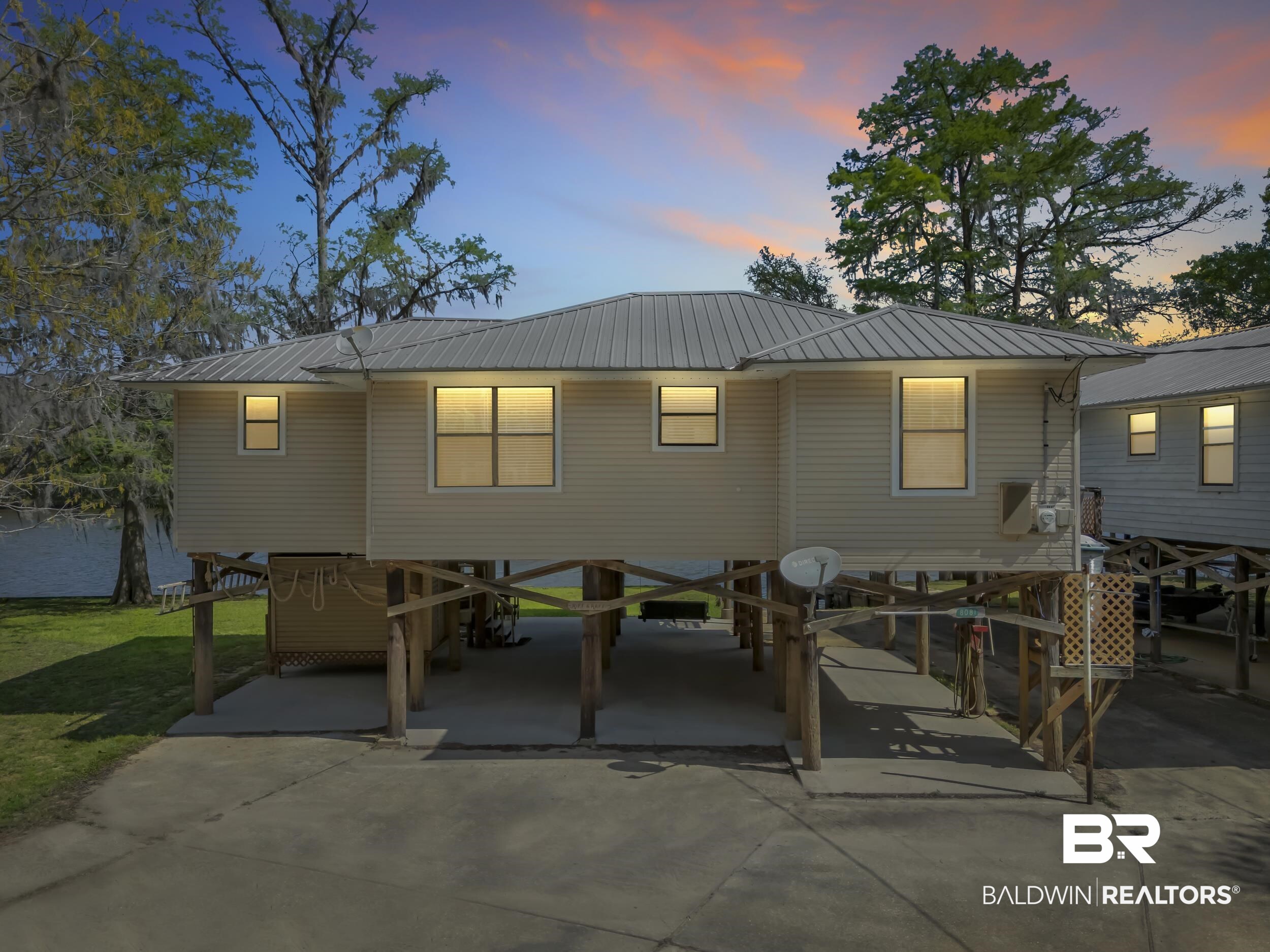 8081 Bryant's Lndg Road Stockton, AL 36579 - Photo 2 of 48 Back of house at dusk featuring a carport, a metal roof, a patio, and concrete driveway
