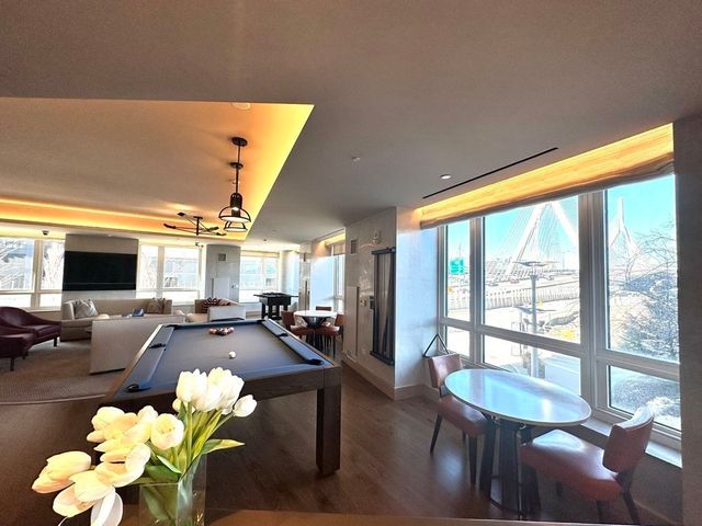 a living room with furniture fireplace and floor to ceiling windows