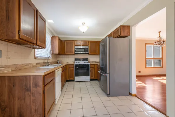 a kitchen with stainless steel appliances granite countertop a refrigerator and a stove top oven