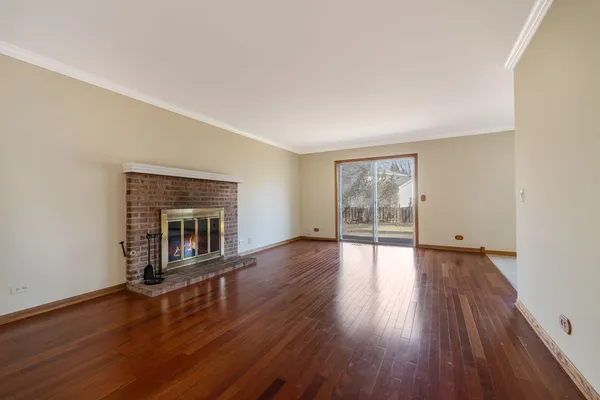 an empty room with wooden floor and fireplace