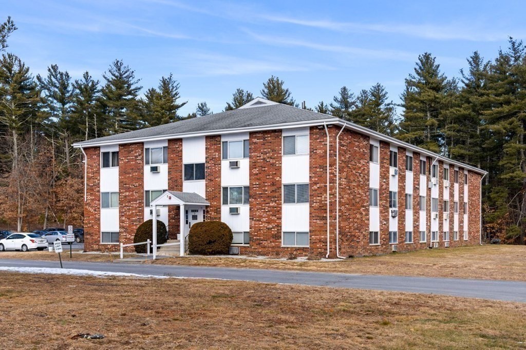 5 Turnpike Road, Unit 233 Townsend, MA 01469 - Photo 1 of 16 a view of a brick building next to a yard with large trees