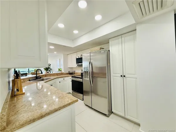 a kitchen with stainless steel appliances granite countertop a sink and cabinets