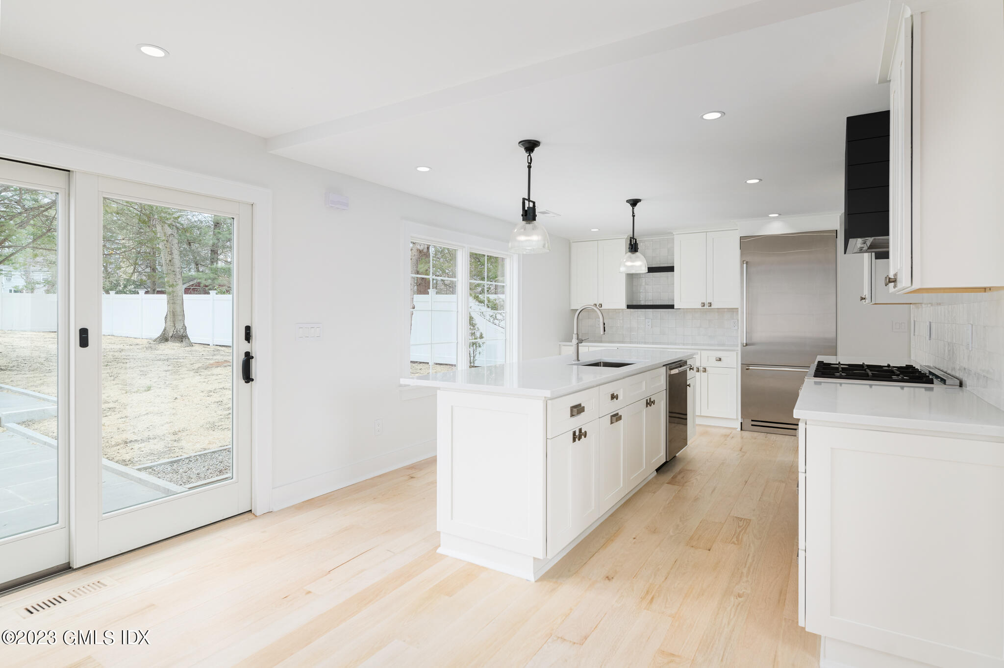 27 Summit Road Riverside, CT 06878 - Photo 9 of 38 a large kitchen with stainless steel appliances kitchen island granite countertop a stove a sink a refrigerator and white cabinets with wooden floor