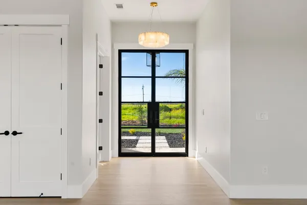 a view of an empty room with a window and a kitchen