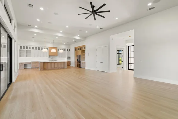 a large kitchen with stainless steel appliances kitchen island a large counter top and a wooden floors